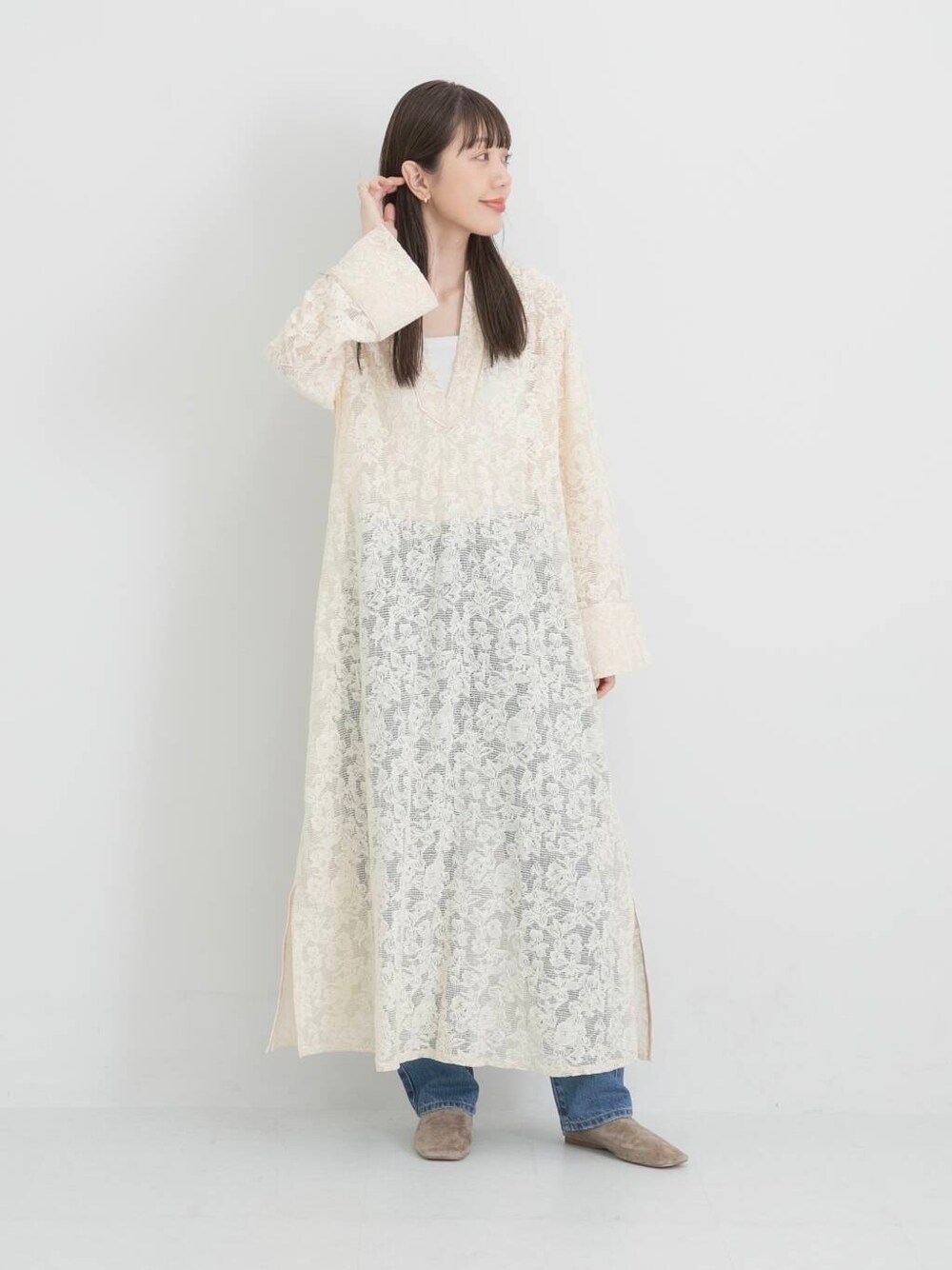 ブルー系のデニムパンツ、ホワイト系のワンピースを着用したレディースの秋コーディネートの1枚目の写真