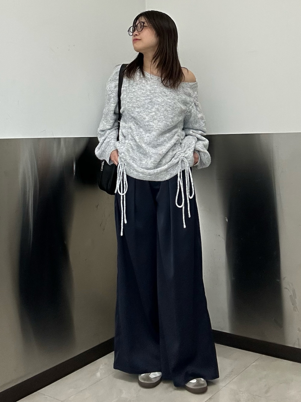 グレー系のニット/セーター、ブルー系のチノパンツ、ホワイト系のスニーカーを着用したレディースの冬コーディネートの1枚目の写真