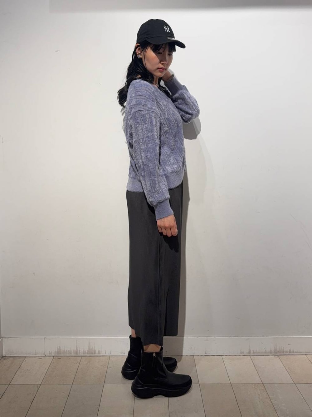 グレー系のスカート、ブラック系のブーツ、パープル系のカーディガン/ボレロを着用したレディースの秋コーディネートの1枚目の写真