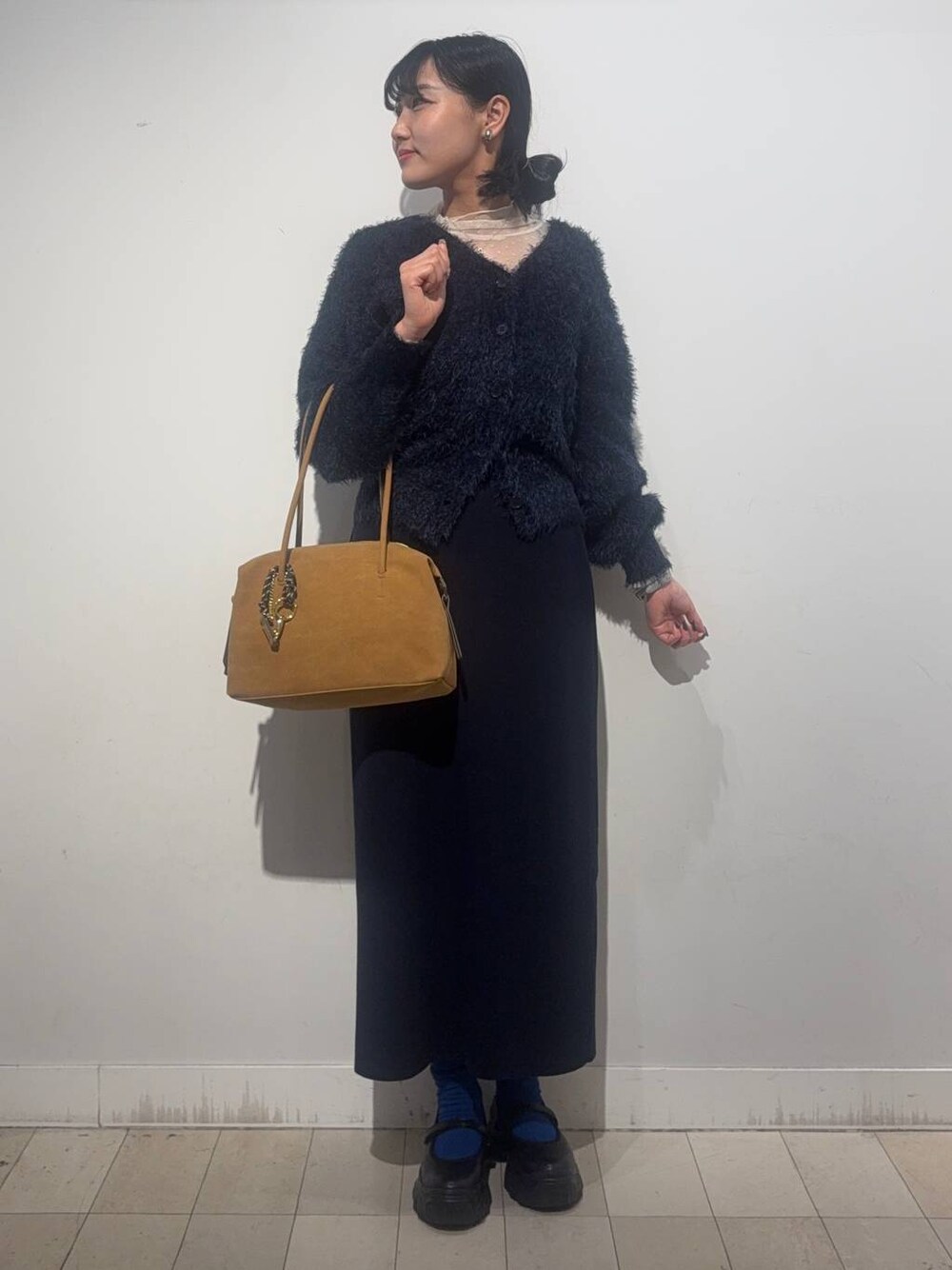 ブラック系のスニーカー、ベージュ系のボストンバッグ、ブルー系のワンピースを着用したレディースの秋コーディネートの1枚目の写真