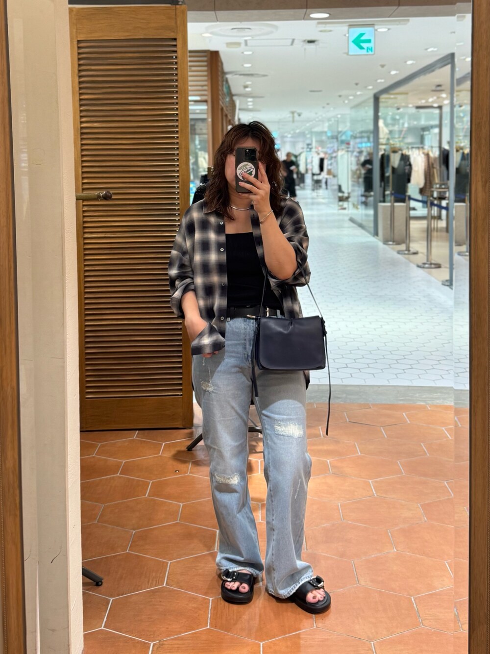 ブラック系のキャミソール、ブルー系のデニムパンツ、ブルー系のショルダーバッグを着用したレディースの夏コーディネートの1枚目の写真