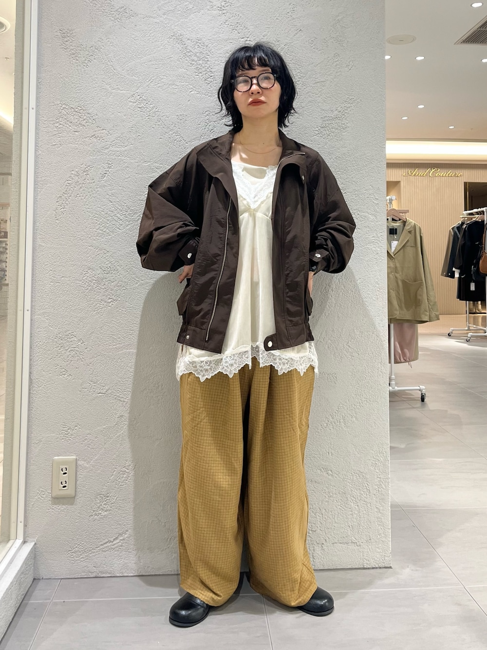 ブラック系のサンダル、イエロー系のその他パンツ、ブラウン系のナイロンジャケットを着用したレディースの秋コーディネートの1枚目の写真