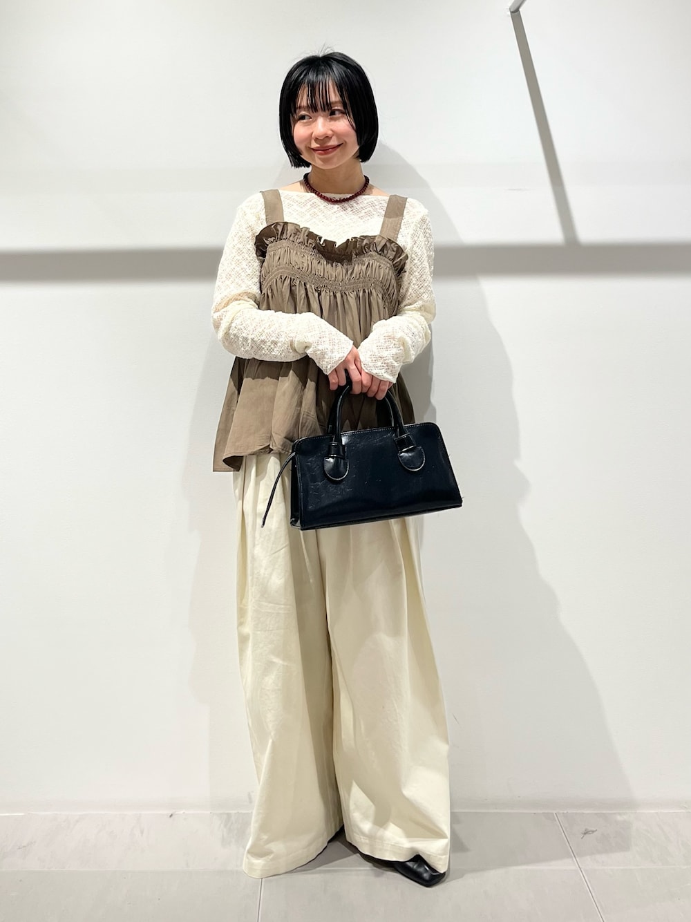 グリーン系のその他トップス、ブラック系のその他シューズ、ホワイト系のその他パンツを着用したレディースの春コーディネートの1枚目の写真