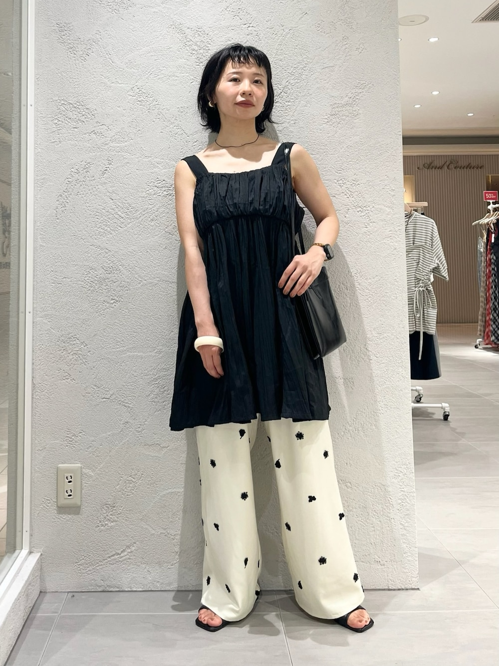 ブラック系のワンピース、ブラック系のサンダル、ホワイト系のその他パンツを着用したレディースの夏コーディネートの1枚目の写真