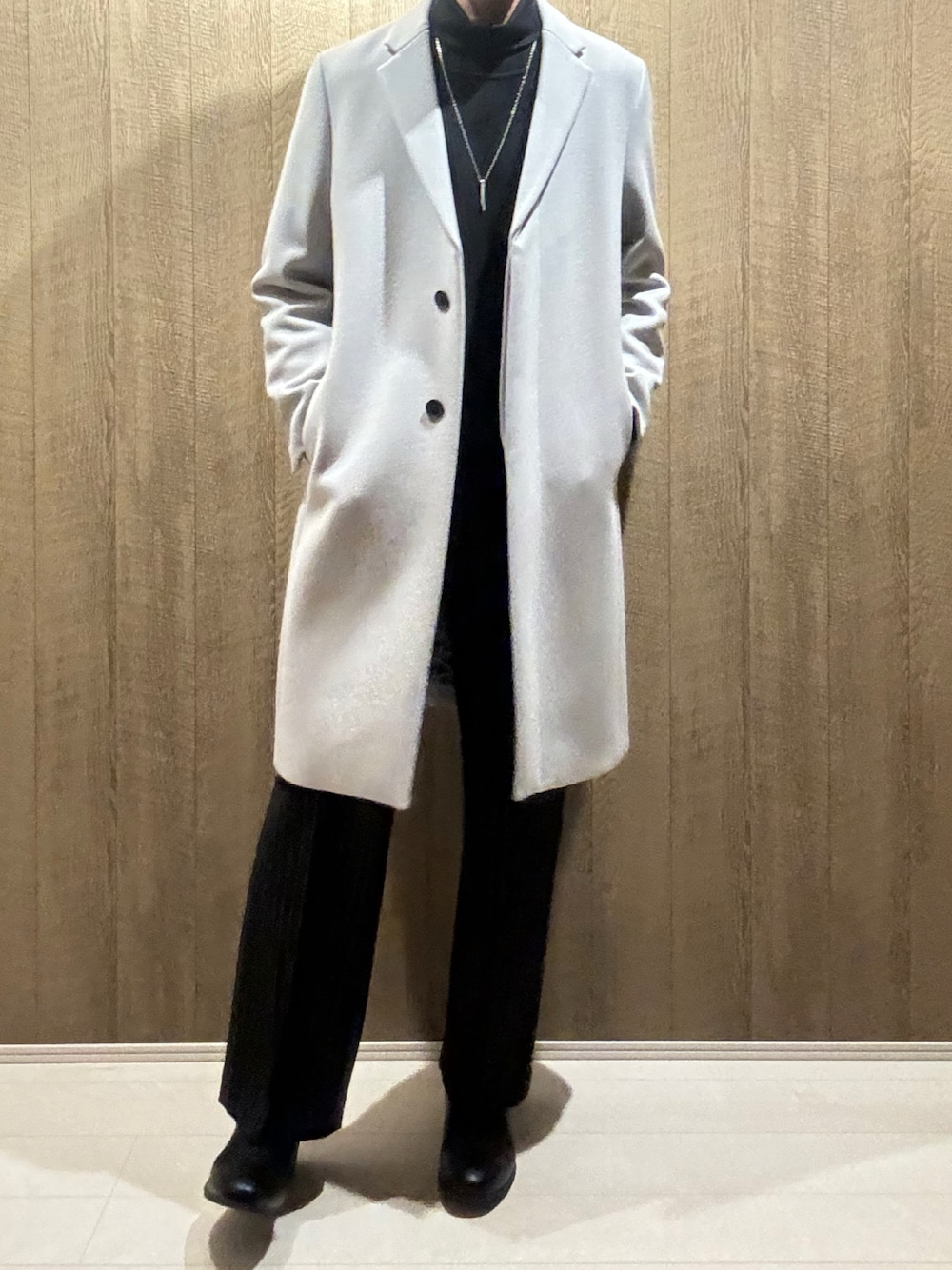 グレー系のチェスターコート、ブラック系のその他パンツ、ブラック系のブーツを着用したメンズの秋コーディネートの1枚目の写真