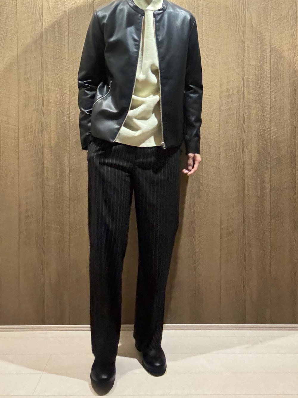 ブラック系のライダースジャケット、ホワイト系のニット/セーター、ブラック系のその他パンツを着用したメンズの秋コーディネートの1枚目の写真