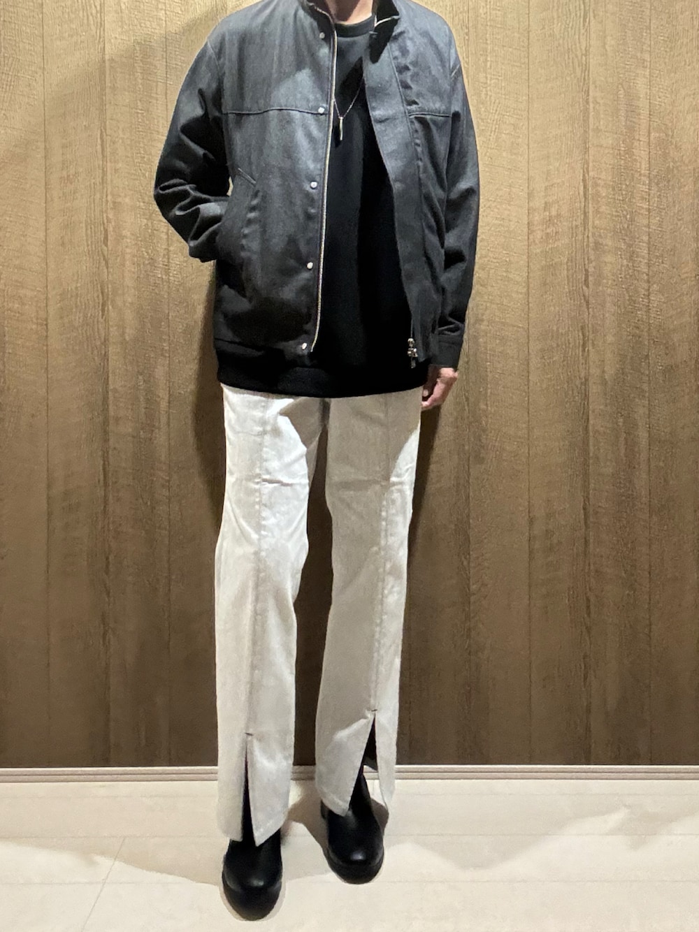 ブラック系のデニムジャケット、ホワイト系のデニムパンツ、ブラック系のブーツを着用したメンズの秋コーディネートの1枚目の写真