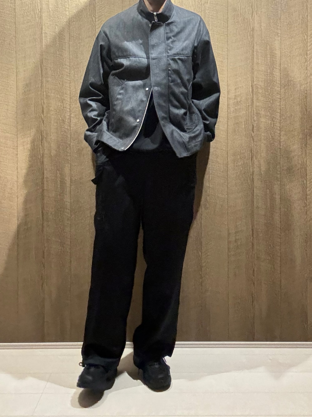 ブラック系のデニムジャケット、ブラック系のカーゴパンツ、ブラック系のスニーカーを着用したメンズの秋コーディネートの1枚目の写真