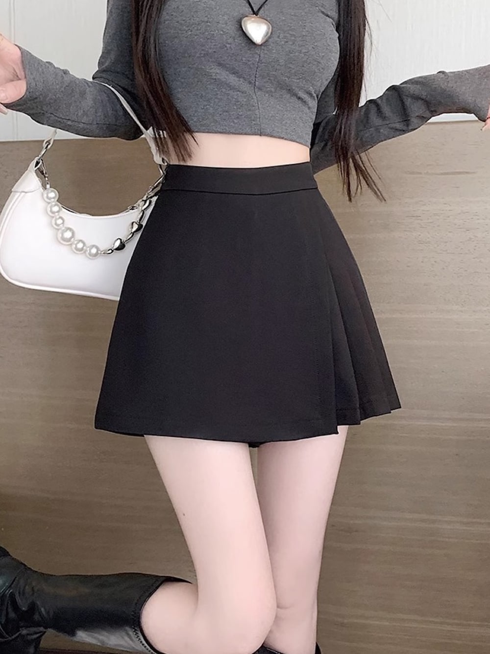 ブラック系のスカートを着用したレディースの秋コーディネートの1枚目の写真