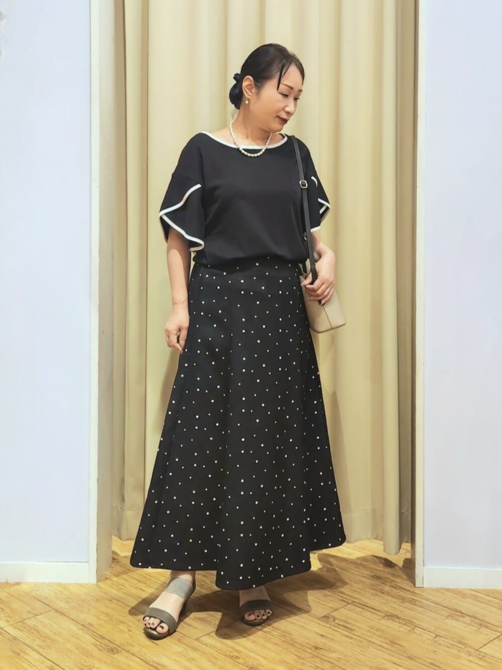 ブラウン系のサンダル、ベージュ系のショルダーバッグ、ブラック系のTシャツ/カットソーを着用したレディースの夏コーディネートの1枚目の写真