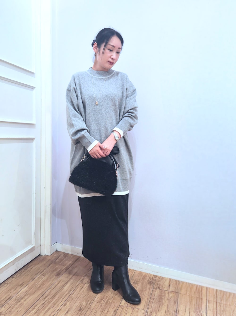 ブラック系のブーツ、ブラック系のスカート、ブラック系のショルダーバッグを着用したレディースの冬コーディネートの1枚目の写真