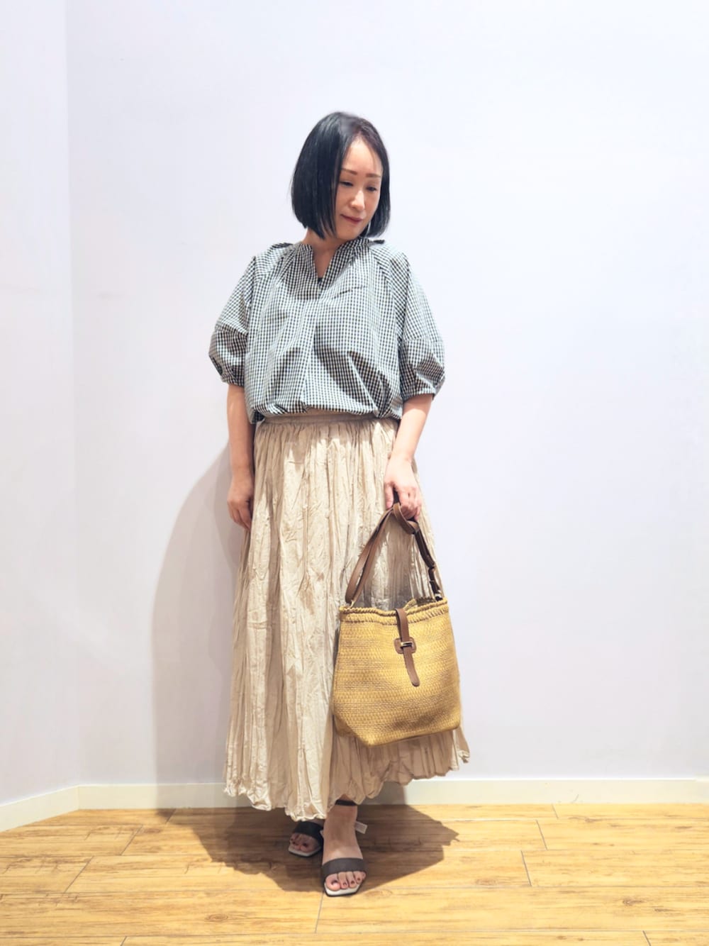ベージュ系のサンダル、ベージュ系のショルダーバッグ、ベージュ系のスカートを着用したレディースの夏コーディネートの1枚目の写真