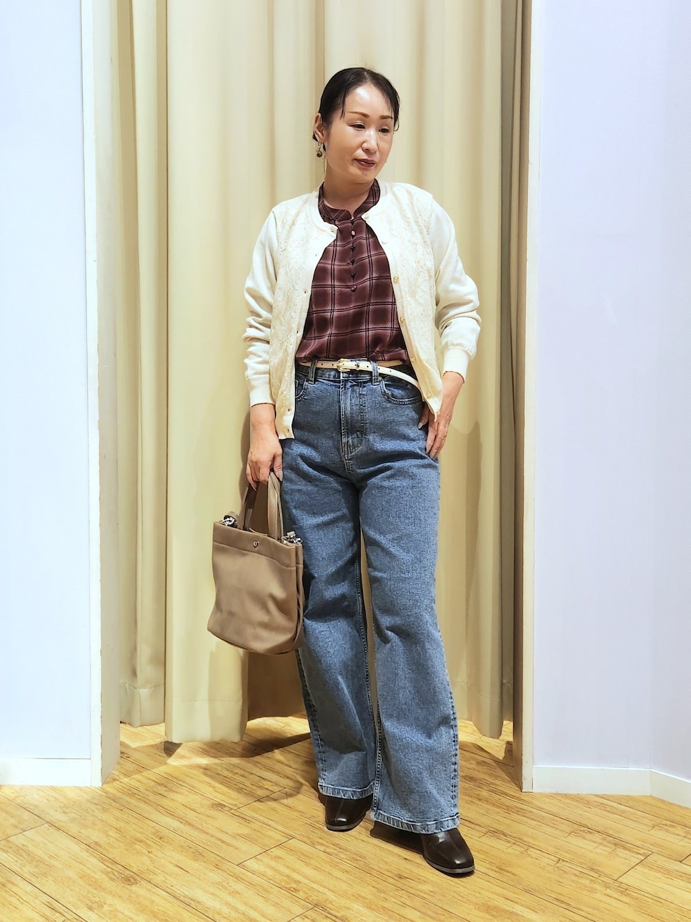 レッド系のシャツ/ブラウス、ホワイト系のカーディガン/ボレロ、ブルー系のデニムパンツを着用したレディースの秋コーディネートの1枚目の写真