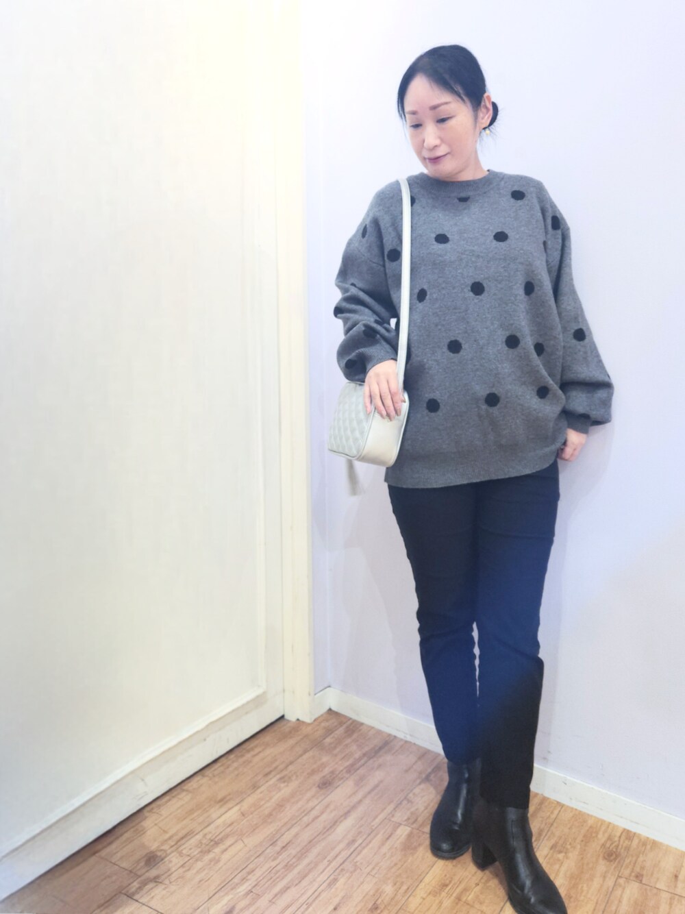 ブラック系のブーツ、シルバー系のショルダーバッグ、ブラック系のその他パンツを着用したレディースの冬コーディネートの1枚目の写真