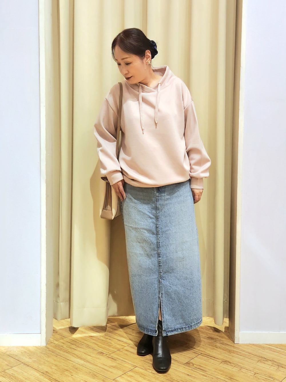 ブルー系のデニムスカート、ベージュ系のショルダーバッグ、ピンク系のTシャツ/カットソーを着用したレディースの冬コーディネートの1枚目の写真