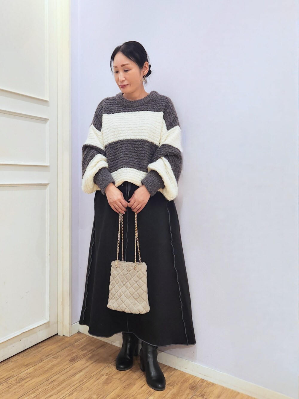 ブラック系のブーツ、ベージュ系のショルダーバッグ、グレー系のニット/セーターを着用したレディースの秋コーディネートの1枚目の写真