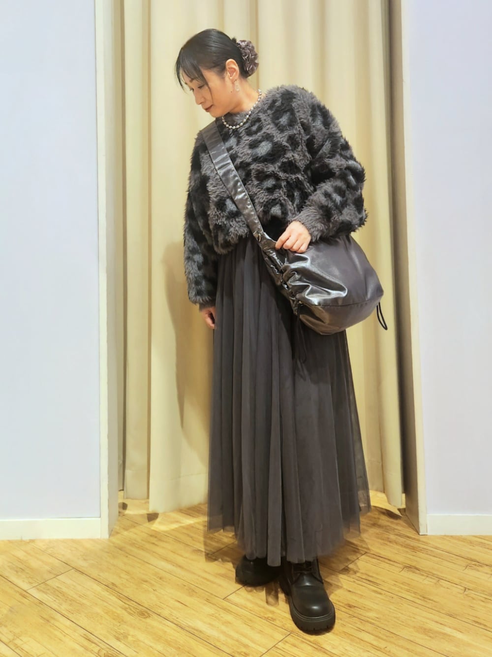 ブラック系のブーツ、グレー系のスカート、グレー系のショルダーバッグを着用したレディースの秋コーディネートの1枚目の写真