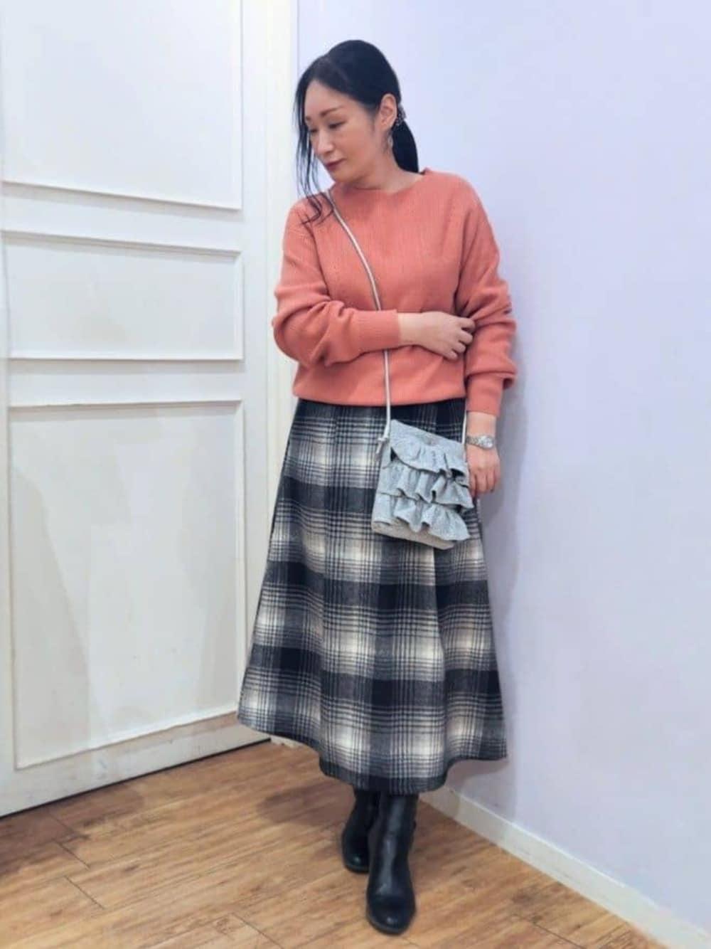 ブラック系のブーツ、ピンク系のニット/セーター、ブラック系のスカートを着用したレディースの秋コーディネートの1枚目の写真