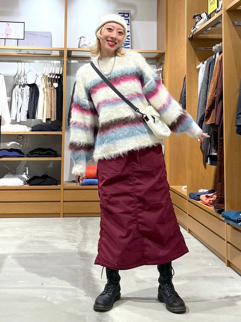 レッド系のスカート、ホワイト系のショルダーバッグ、ホワイト系のニット/セーターを着用したレディースの冬コーディネートの1枚目の写真