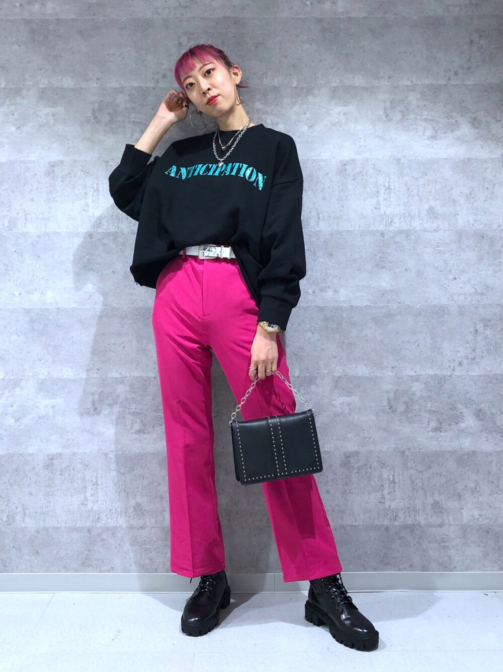 ブラック系のスウェット、ピンク系のスラックス、ブラック系のショルダーバッグを着用したレディースの秋コーディネートの1枚目の写真