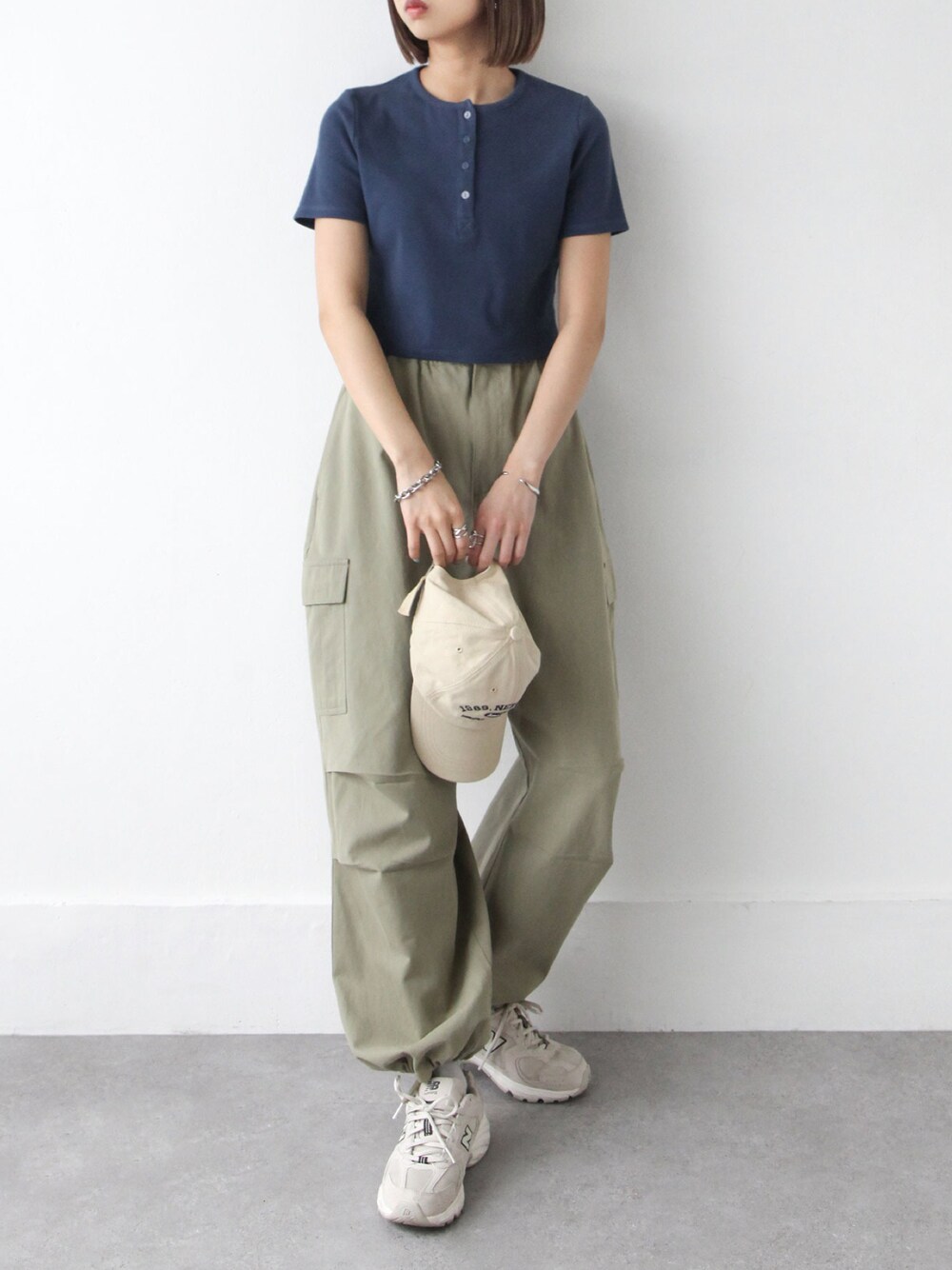 ブルー系のTシャツ/カットソー、ベージュ系のカーゴパンツ、ベージュ系のキャップを着用したレディースの春コーディネートの1枚目の写真