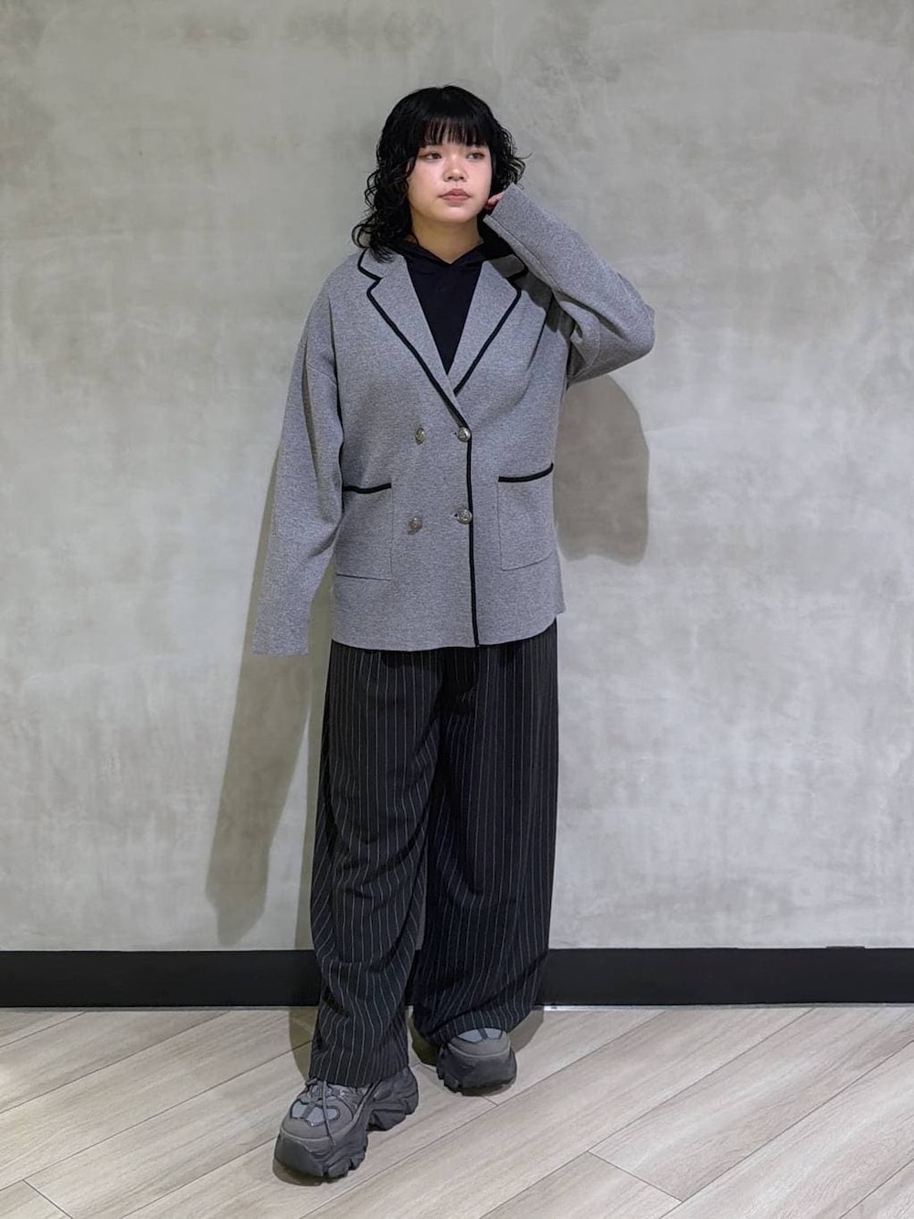 グレー系のスニーカー、ブラック系のスラックス、グレー系のテーラードジャケットを着用したレディースの冬コーディネートの1枚目の写真