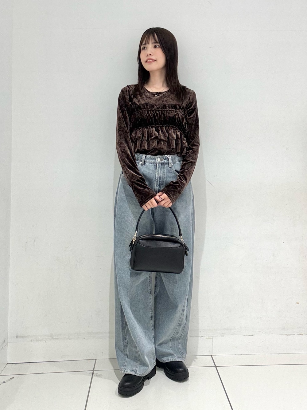 ブラウン系のTシャツ/カットソー、ブルー系のデニムパンツ、ブラック系のショルダーバッグを着用したレディースの冬コーディネートの1枚目の写真