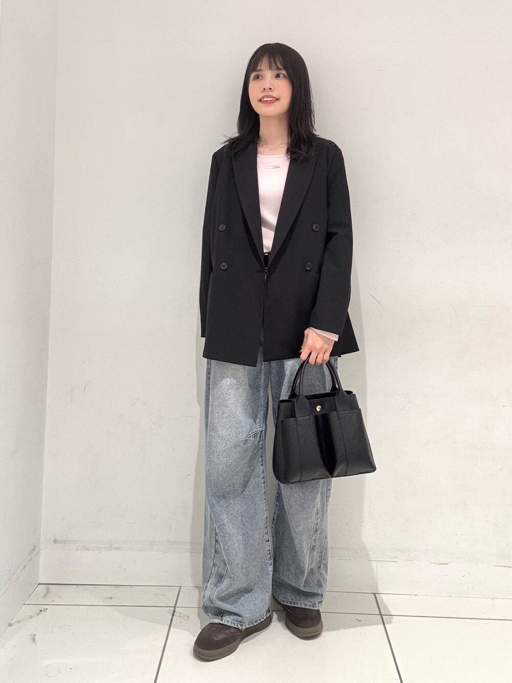 ピンク系のTシャツ/カットソー、ブラック系のその他アウター、ブルー系のデニムパンツを着用したレディースの秋コーディネートの1枚目の写真