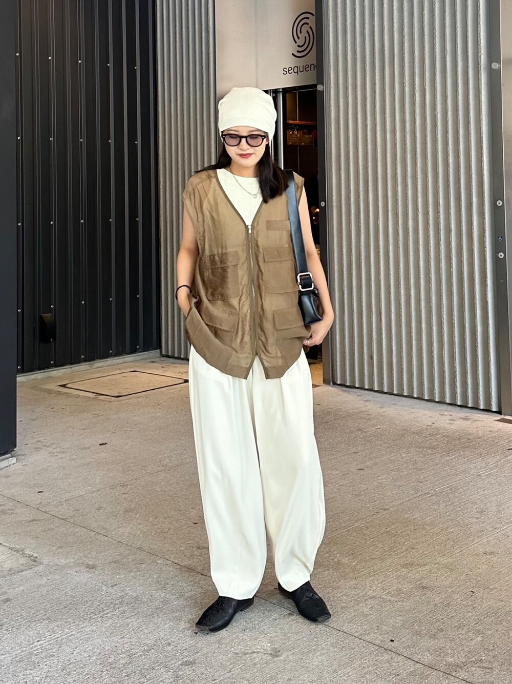 グリーン系のジャケット/アウター、グレー系のパンツ、ホワイト系のタンクトップを着用したレディースの夏コーディネートの1枚目の写真