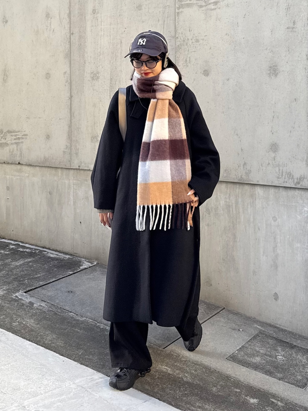 ブラック系のチェスターコート、ブラック系のその他アウター、ブラウン系のマフラーを着用したレディースの秋コーディネートの1枚目の写真