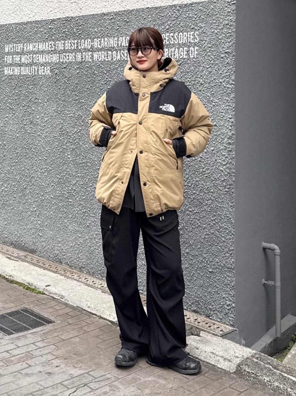 ホワイト系のカーゴパンツ、ブラック系のサングラスを着用したレディースの冬コーディネートの1枚目の写真