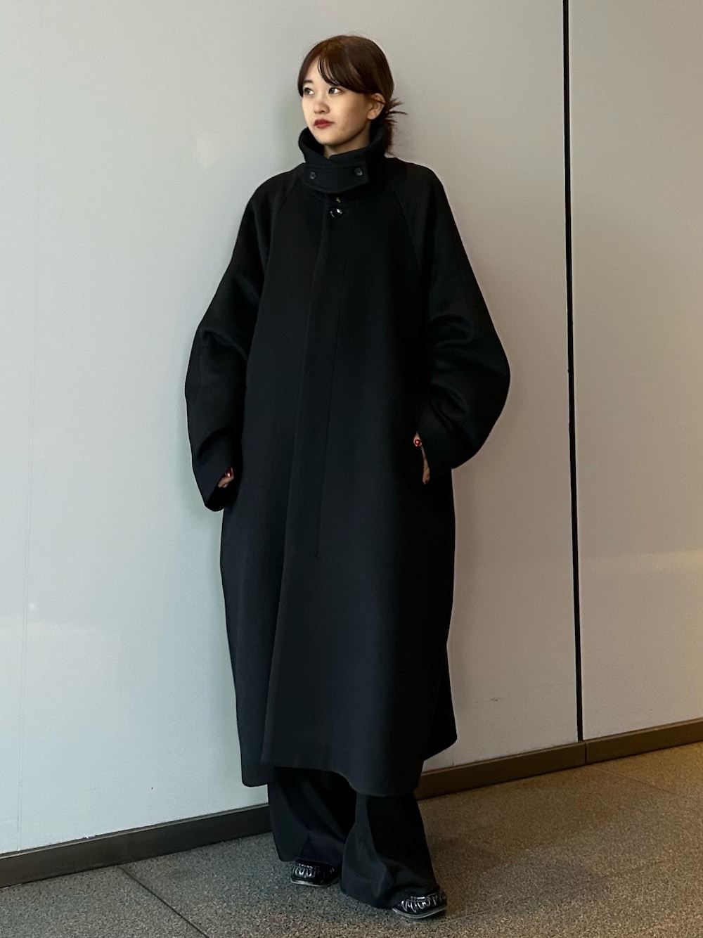 ブラック系のその他アウター、ブラック系のスラックスを着用したレディースの冬コーディネートの1枚目の写真