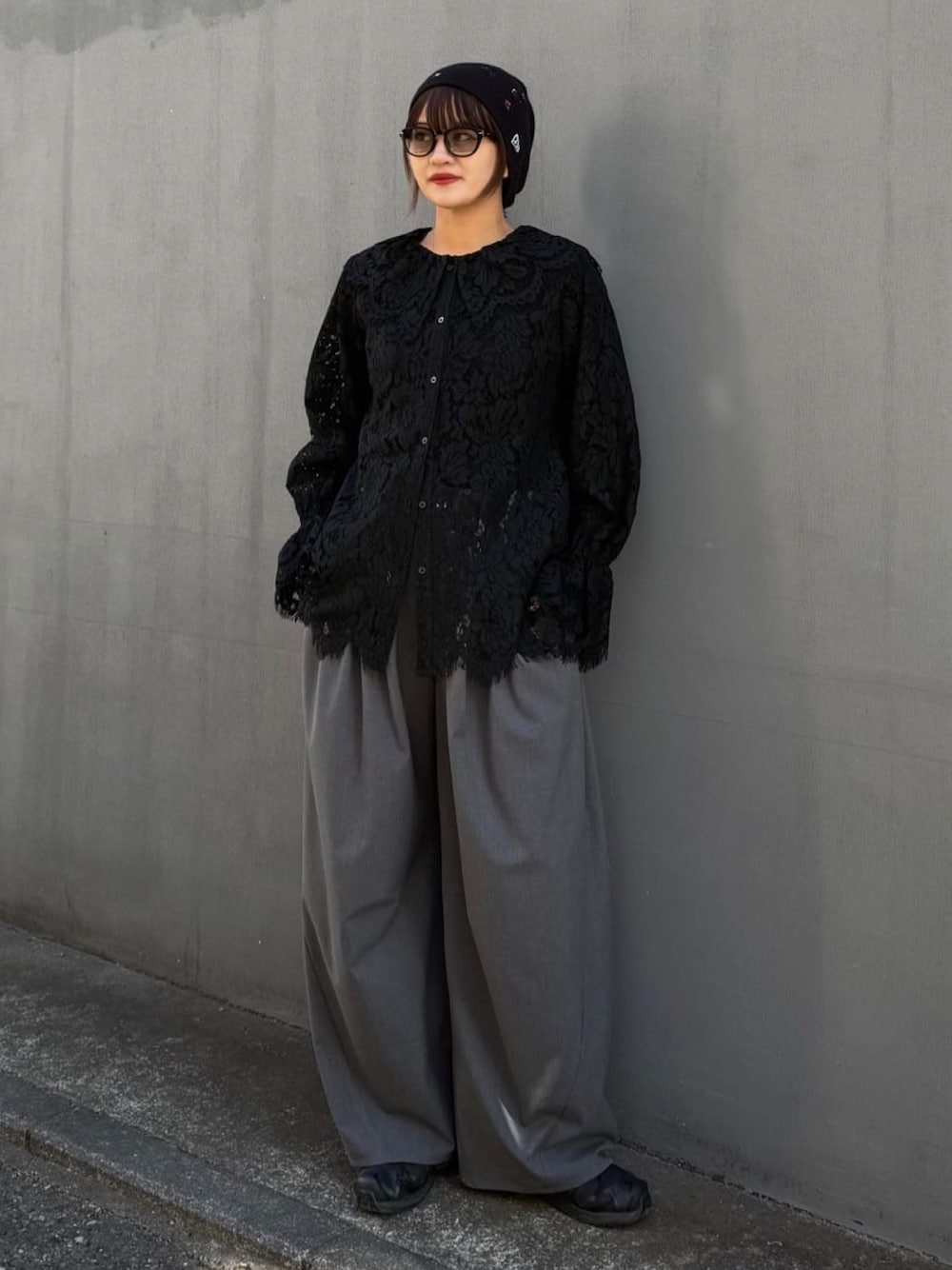 ブラック系のシャツ/ブラウス、グレー系のスラックスを着用したレディースの冬コーディネートの1枚目の写真