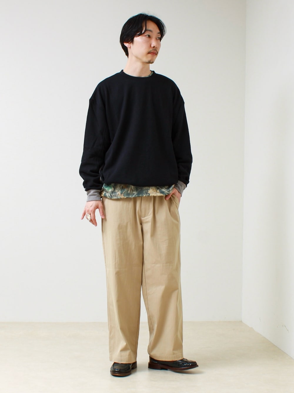 ブラック系のTシャツ/カットソー、その他のスウェット、ベージュ系のその他パンツを着用したメンズの春コーディネートの1枚目の写真