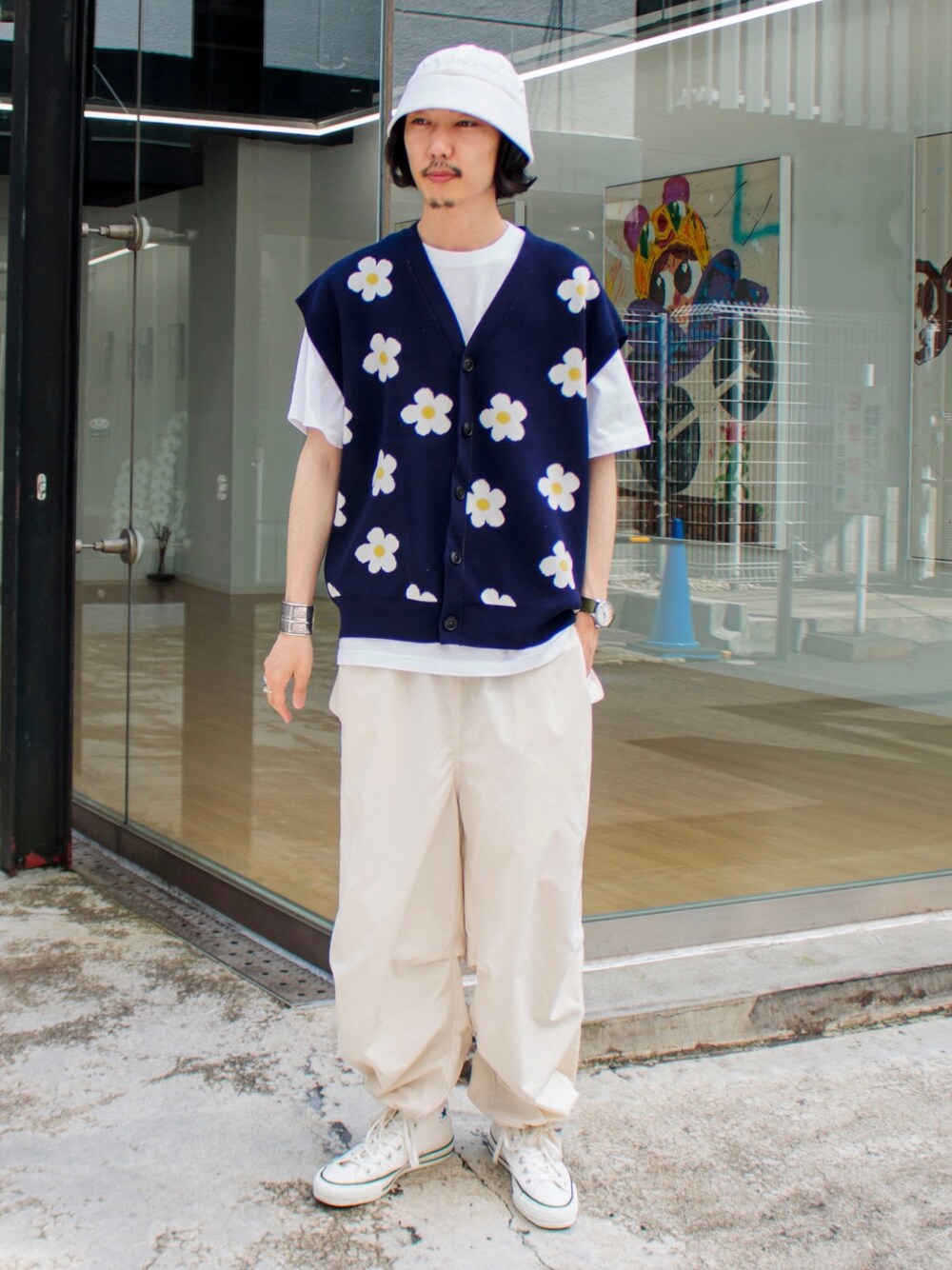 ブルー系のベスト、ホワイト系のその他パンツ、ホワイト系のスニーカーを着用したメンズの春コーディネートの1枚目の写真