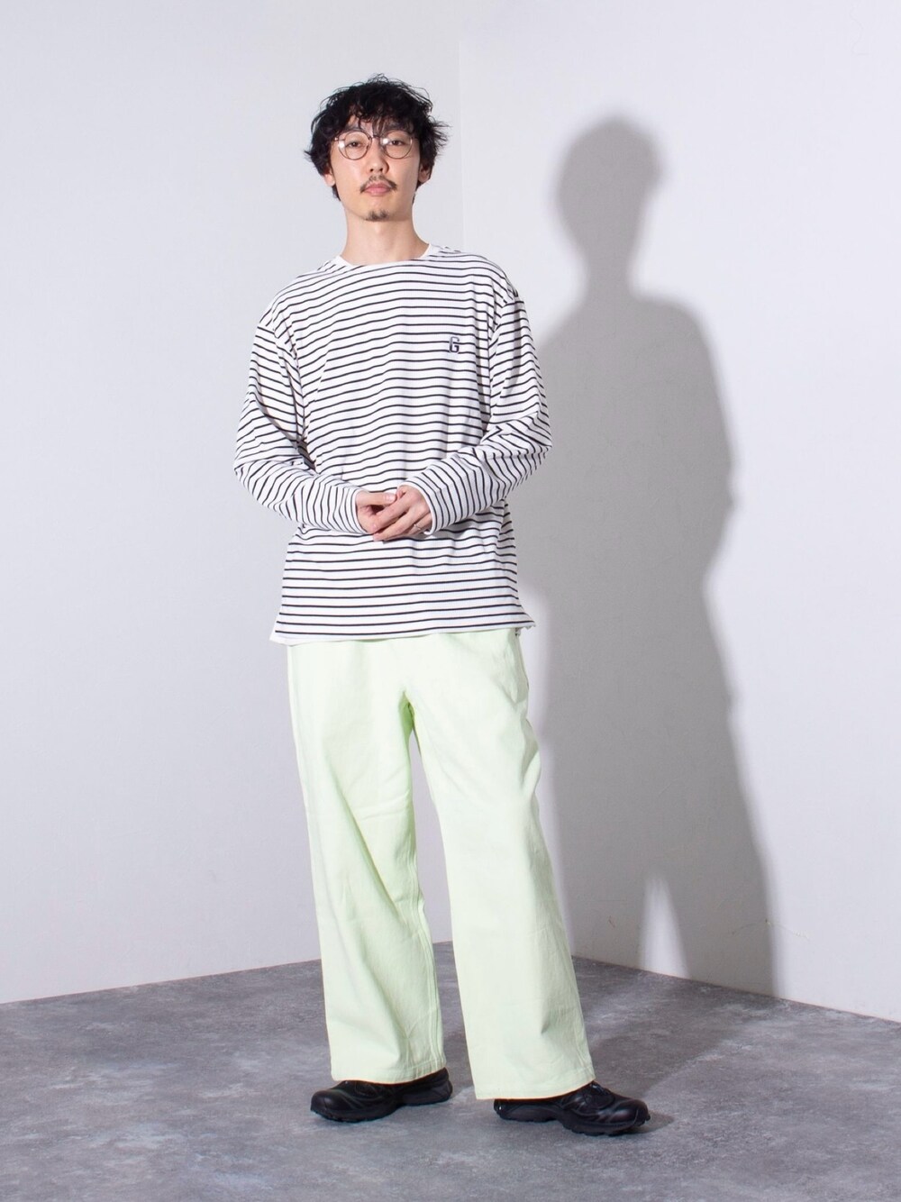 ブラック系のTシャツ/カットソー、グリーン系のデニムパンツを着用したメンズの冬コーディネートの1枚目の写真