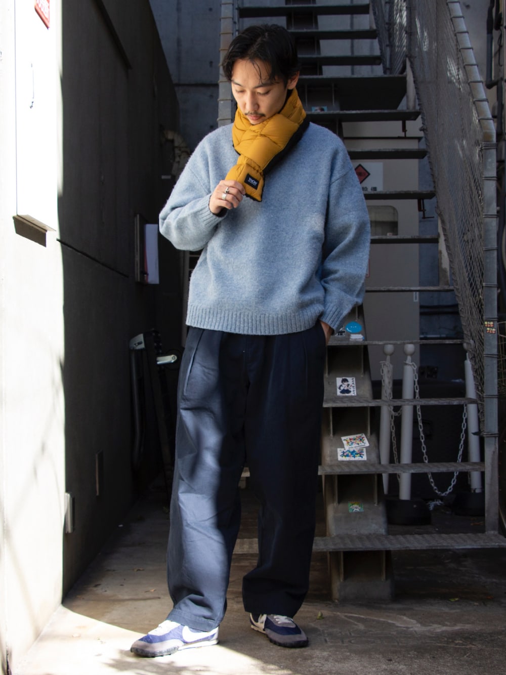 ブルー系のニット/セーター、ブルー系のチノパンツ、ブルー系のスニーカーを着用したメンズの秋コーディネートの1枚目の写真