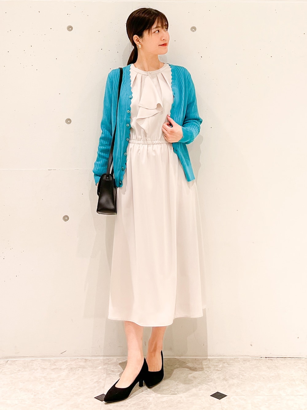 ベージュ系のワンピース、ブラック系のショルダーバッグ、ブルー系のカーディガン/ボレロを着用したレディースの春コーディネートの1枚目の写真