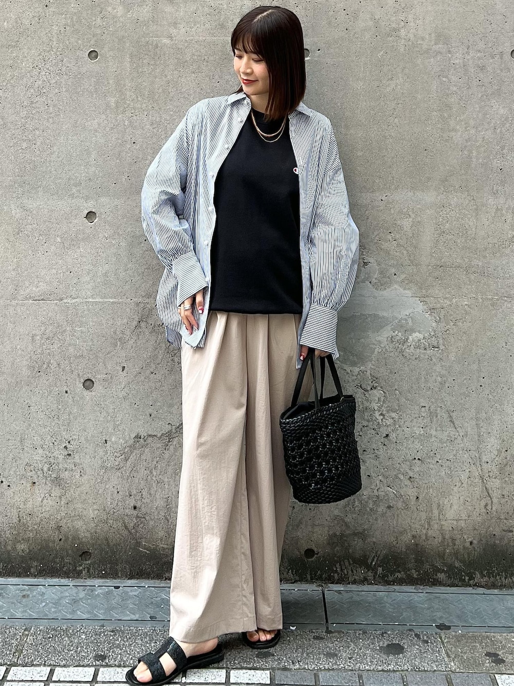 ベージュ系のその他パンツ、ブラック系のトートバッグ、ブルー系のシャツ/ブラウスを着用したレディースの春コーディネートの1枚目の写真