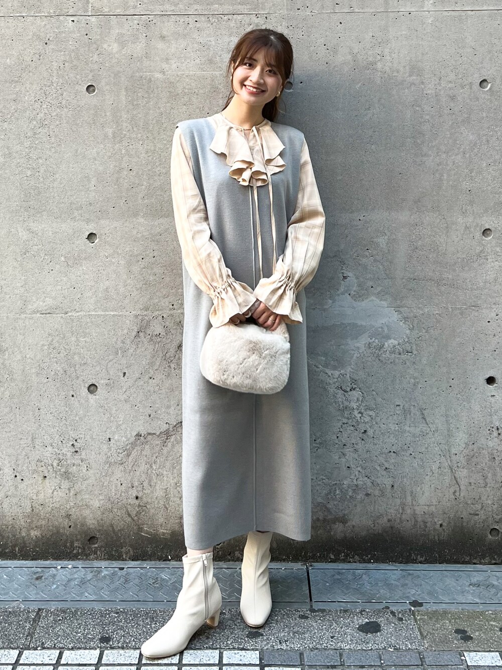 グレー系のジャンパースカート、ベージュ系のショルダーバッグ、ベージュ系のシャツ/ブラウスを着用したレディースの秋コーディネートの1枚目の写真