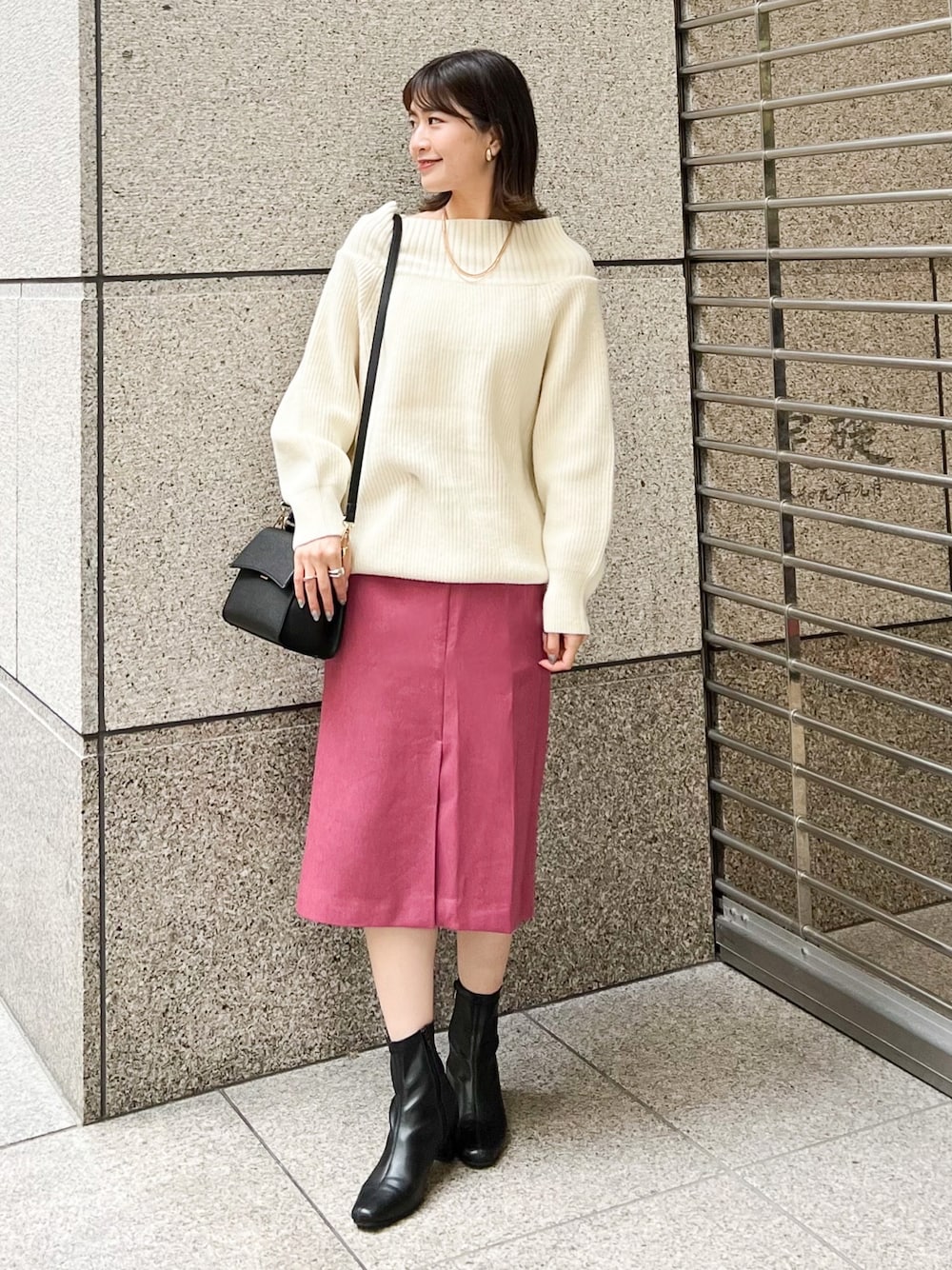 ホワイト系のニット/セーター、ブラック系のショルダーバッグ、ピンク系のスカートを着用したレディースの冬コーディネートの1枚目の写真