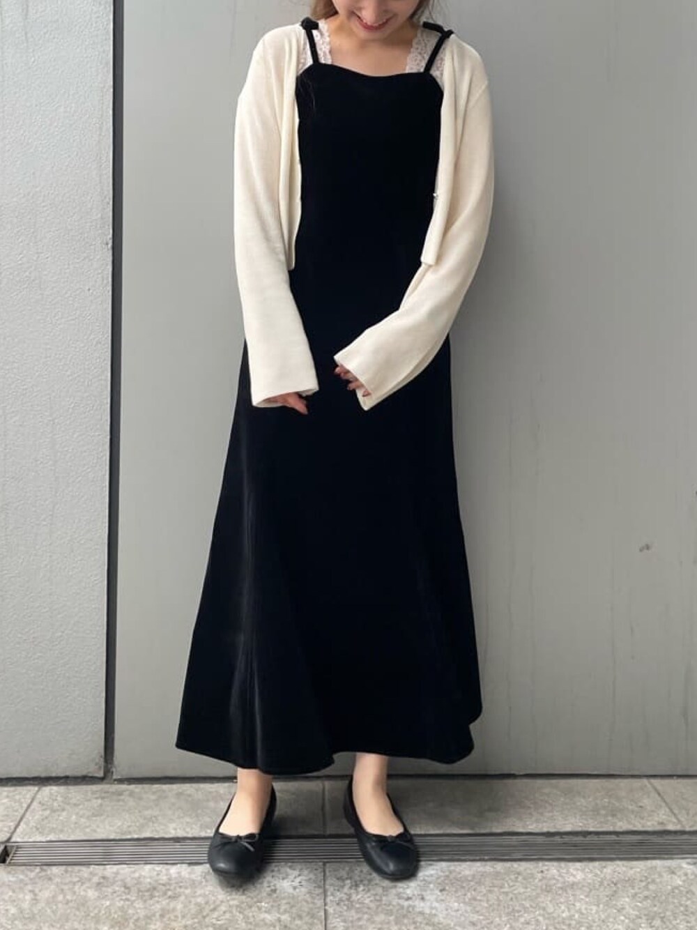 ブラック系のワンピース、ホワイト系のカーディガン/ボレロを着用したレディースの秋コーディネートの1枚目の写真