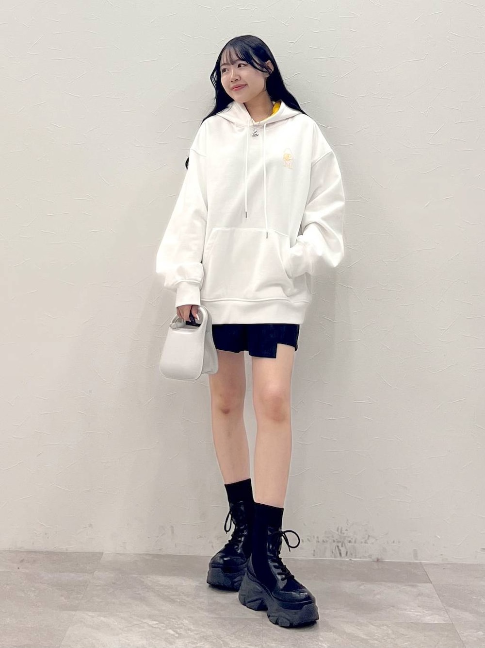 ブラック系のブーツ、ブラック系のその他パンツ、ホワイト系のパーカーを着用したレディースの冬コーディネートの1枚目の写真