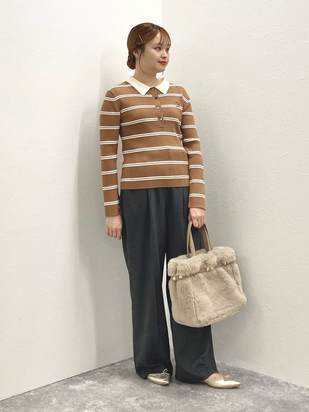 グレー系のその他パンツ、ブラウン系のニット/セーター、ベージュ系のトートバッグを着用したレディースの秋コーディネートの1枚目の写真