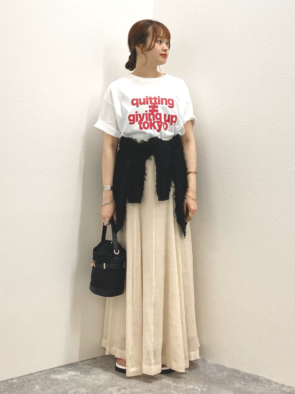 ホワイト系のTシャツ/カットソー、ベージュ系のスカート、ブラック系のカーディガン/ボレロを着用したレディースの夏コーディネートの1枚目の写真