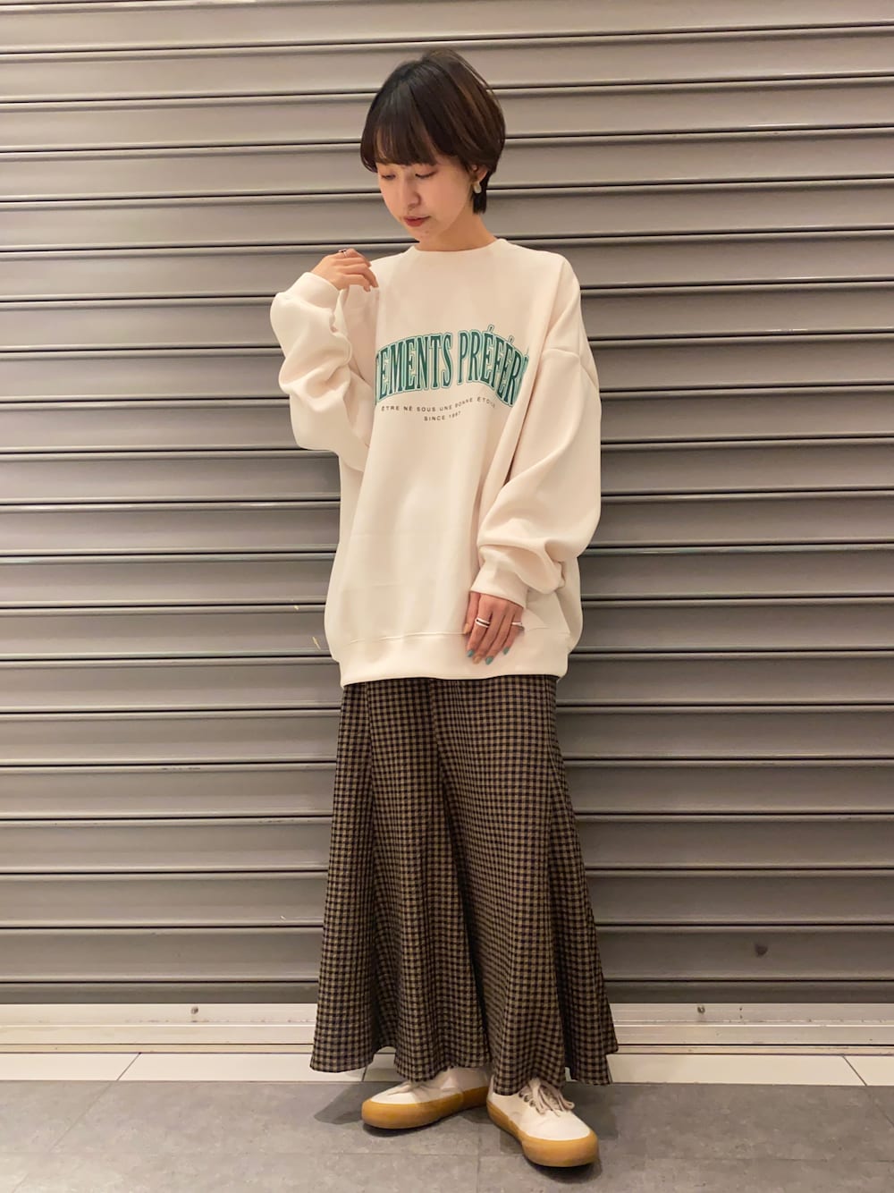 ホワイト系のスウェット、ブラウン系のスカートを着用したレディースの春コーディネートの1枚目の写真