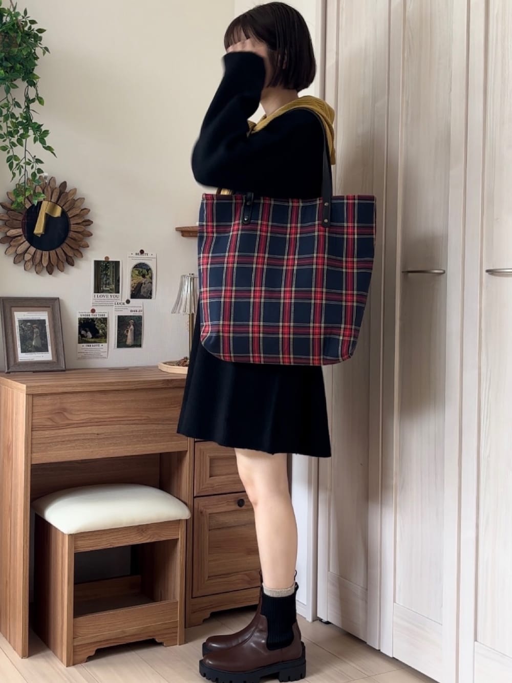 ブラック系のワンピース、ブラウン系のブーツを着用したレディースの秋コーディネートの1枚目の写真