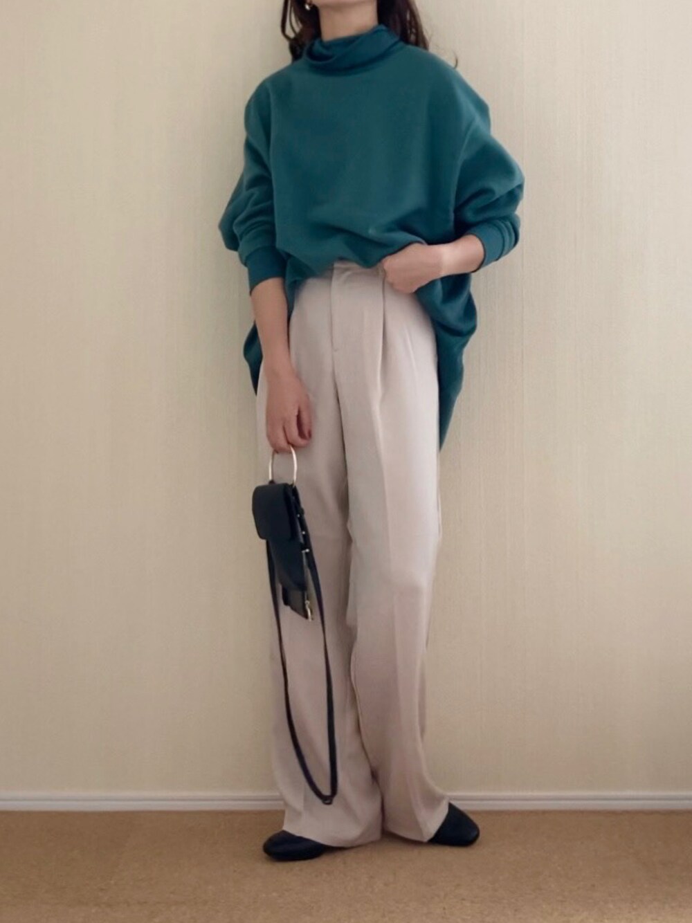 グリーン系のスウェット、ベージュ系のスラックス、ブラック系のショルダーバッグを着用したレディースの秋コーディネートの1枚目の写真