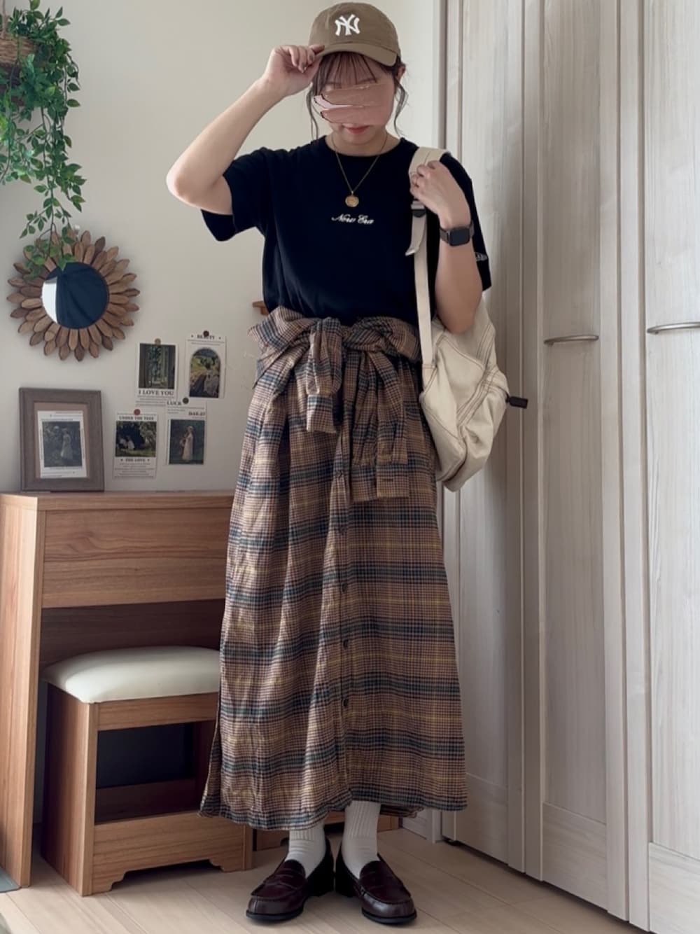 ブラック系のTシャツ/カットソー、ベージュ系のキャップを着用したレディースの秋コーディネートの1枚目の写真