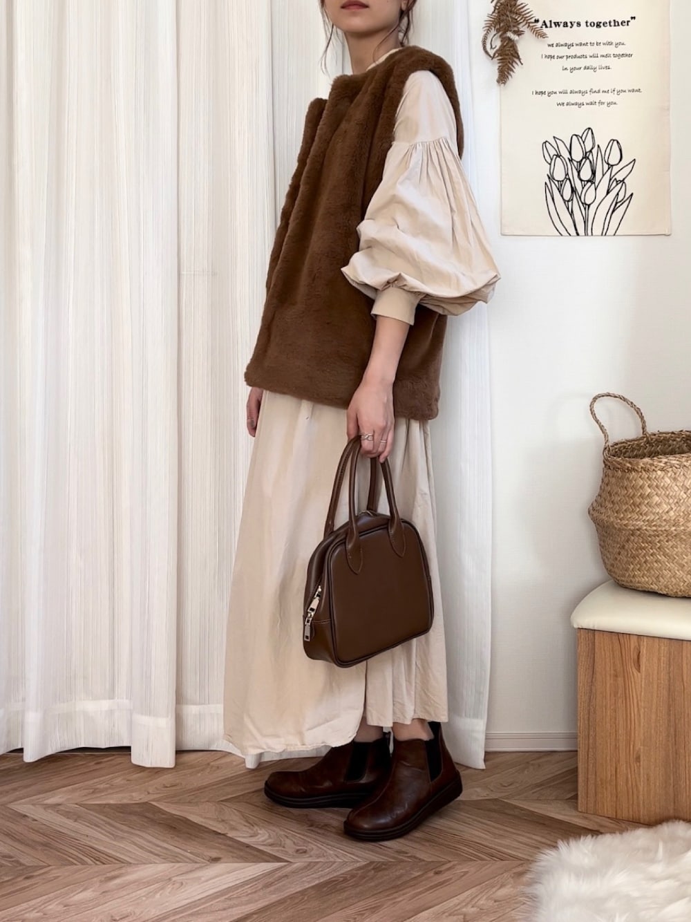ブラウン系のベスト、ベージュ系のシャツワンピース、ブラウン系のボストンバッグを着用したレディースの秋コーディネートの1枚目の写真